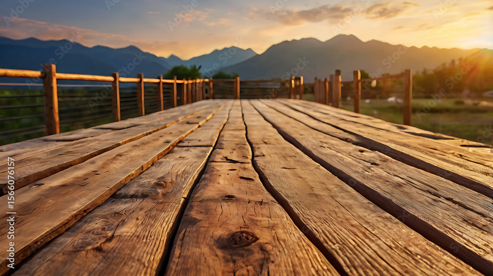 Naklejka premium A wooden walkway leading toward a mountain range at sunset. Blurred background for text placement. Natural golden lighting. 