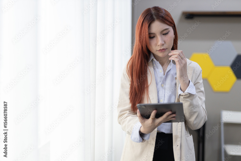 Sleek office setting, businesswomen with red hair use tablet while thoughtfully contemplating something important. Sleek office setting, businesswomen with red hair use tablet while thoughtfully contemplating something important.