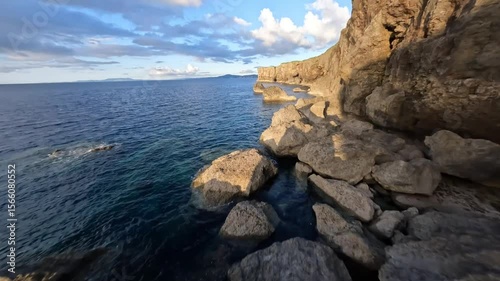 Bird's eye view of flying above beautiful sea and cliff in Okinawa at the sunset
