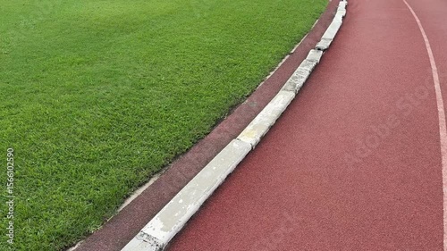 Running track and football pitch green grass. POV shot