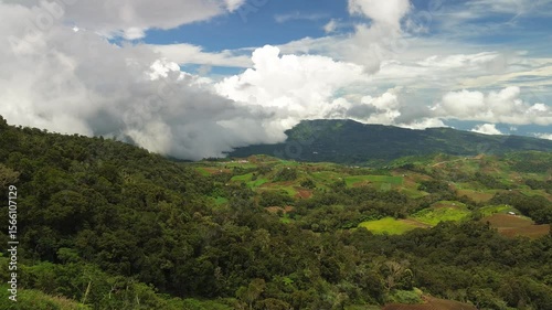 Wallpaper Mural A sweeping pass over Mount Apo’s foothills reveals green crop terraces and forested ridges while towering cumulus clouds cascade across the distant horizon. Torontodigital.ca