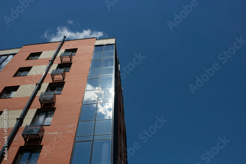 Wallpaper Mural The glass facade of the red brick building reflects the blue sky with white clouds. Torontodigital.ca