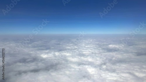 Airplane flying above the clouds. Plane window view. Panoramic view from a plane window. Cloudscape.