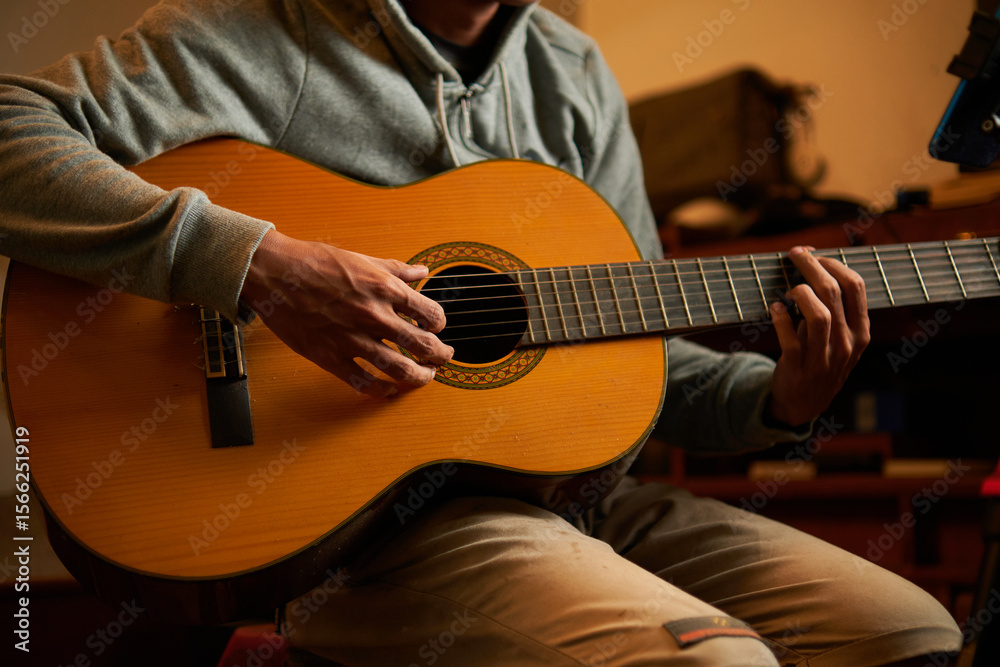 Obraz premium man playing acoustic guitar in his studio