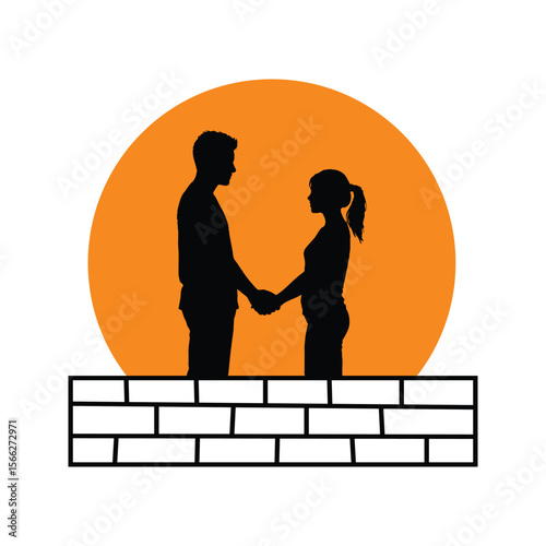 Silhouette of Couple Holding Hands Against Orange Sunset Over Brick Wall