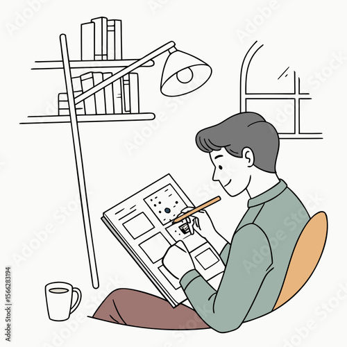 A person drawing on a large book while sitting in a chair under a lamp with books on a shelf nearby