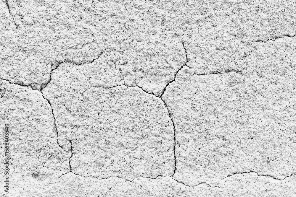 Fototapeta premium Cracked surface reveals textures of aging concrete in monochrome hues