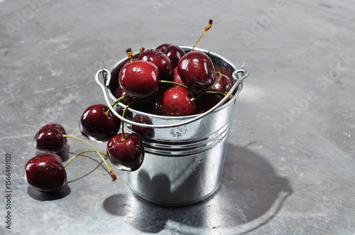 Cherries in a metal containerl with water drops close up on a vintage background