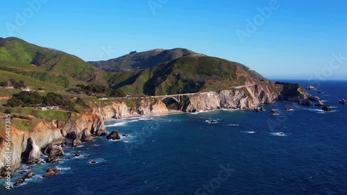 Cinematic aerial drone footage of Bixby Creek Bridge along the Pacific Coast Highway in Big Sur, California. Captured in 4K resolution during golden hour, the iconic bridge with ocean cliffs USA