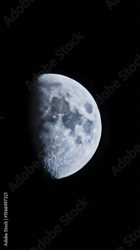 A close up of the moon in a dark sky showing craters and the texture of the lunar surface clearly