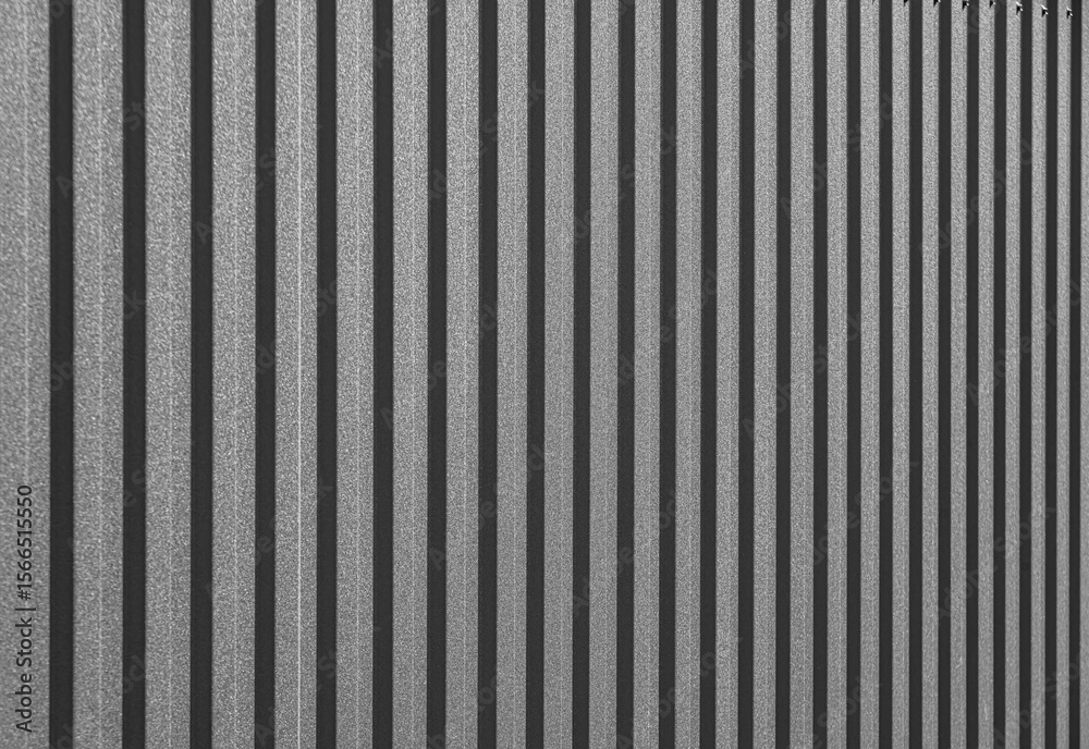 Obraz premium Corrugated metal sheet surface with diagonal ridges, showing detailed texture and pattern commonly used in industrial and construction applications.