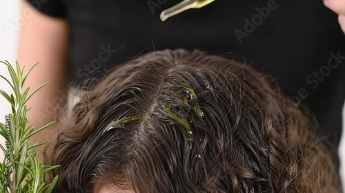 Close-up of an oil treatment being applied to a person's scalp.