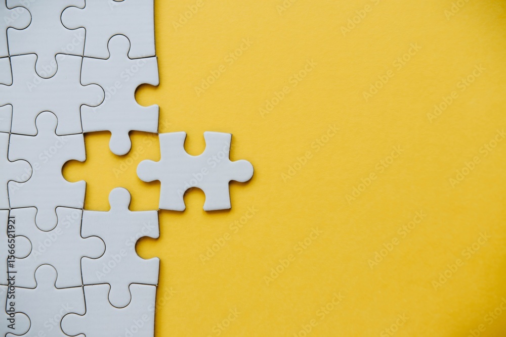 Obraz premium Missing puzzle piece on yellow background problem solving teamwork connection concept with copy space.