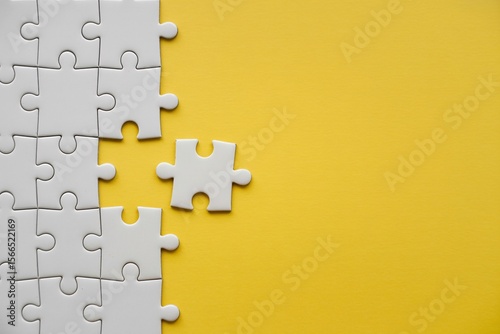 Missing puzzle piece on yellow background problem solving teamwork connection concept with copy space.