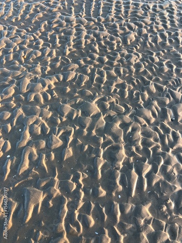 gray beach wavy sand ripples dune texture wallpaper pattern background close-up