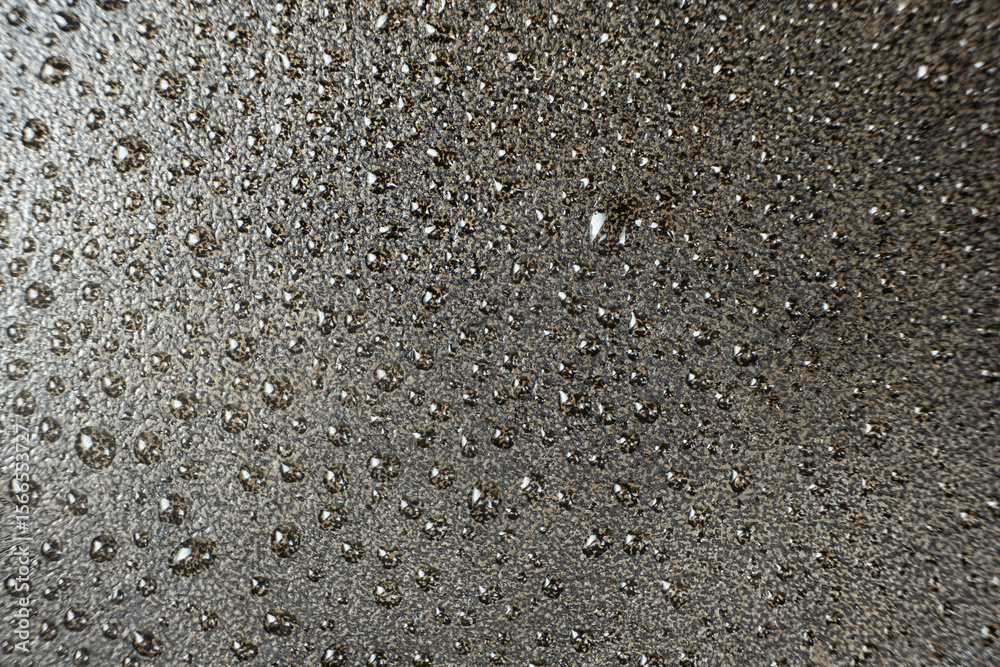 Fototapeta premium Water droplets on a cast iron macro surface. Cast iron cookware care, rust resistant, abstract pattern