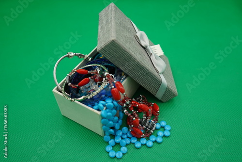 Colorful jewelry box displays a vibrant assortment of necklaces and bracelets nestled among glistening beads