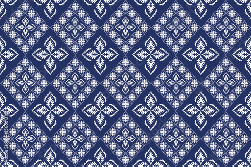 This design displays a symmetrical diamond layout with alternating floral and geometric motifs in white over a deep blue background, evoking traditional Thai textile elegance.