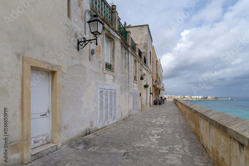 A narrow alleyway lined with colored mansions in Otranto, Apulia, Southern Italy