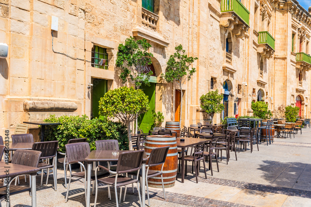 Fototapeta premium A cafe with outdoor sitting area in Valletta waterfront in Floriana, outside of Valletta, Malta.