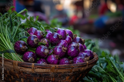 A basket full of purple onions and green herbs