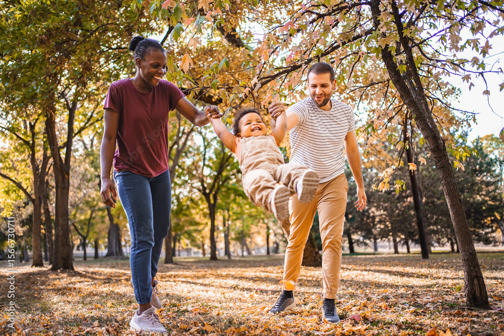 Fototapeta premium Joyful swing between parents in the park