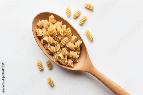 Wooden spoon with uncooked tortiglioni pasta on white background