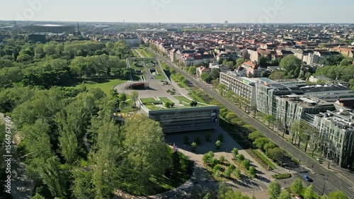 Drone video zooming out from the Museum of Ethnography, revealing City Park and Puskás Aréna in soft morning light with a wide aerial view of Budapest’s cultural district.  