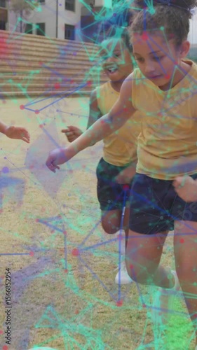 Animation of networks over happy diverse schoolgirls playing football in sports field