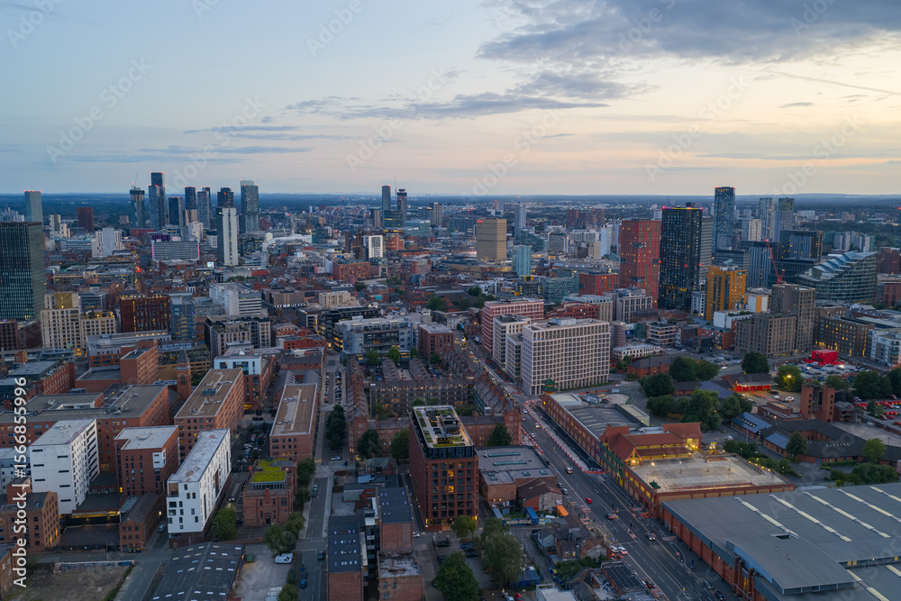 Obraz premium Aerial view of Manchester’s skyline with clustered tall modern towers photographed over Ancoats area. 