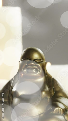 Animation of white light spots over buddha statue and candles