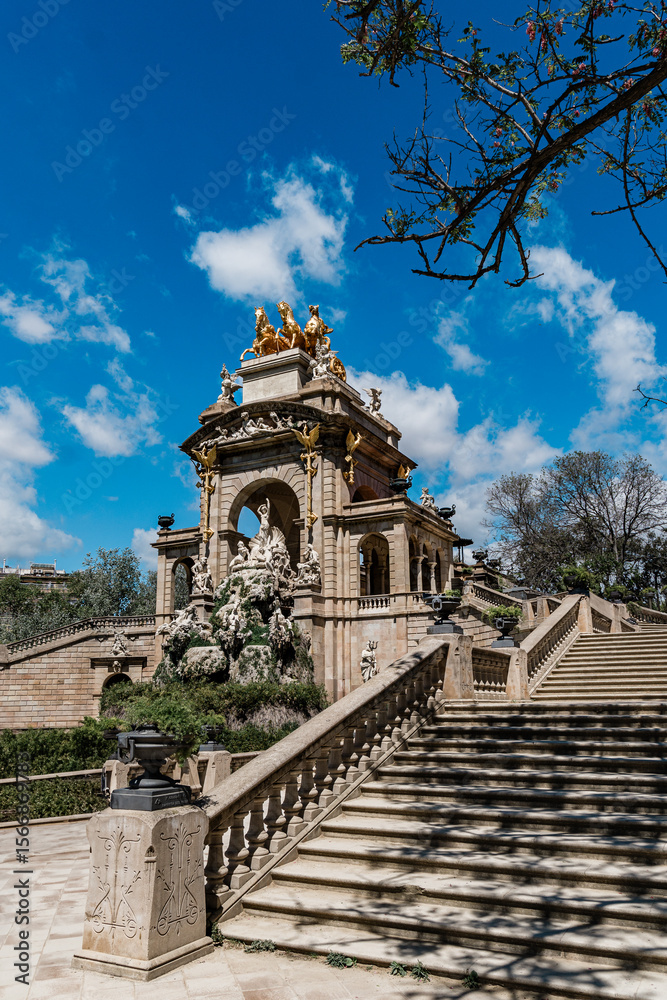 Obraz premium The ornate Cascada Monumental in Barcelona features elaborate sculptures and a golden chariot statue, viewed from the grand staircase below, Ciutadella Park