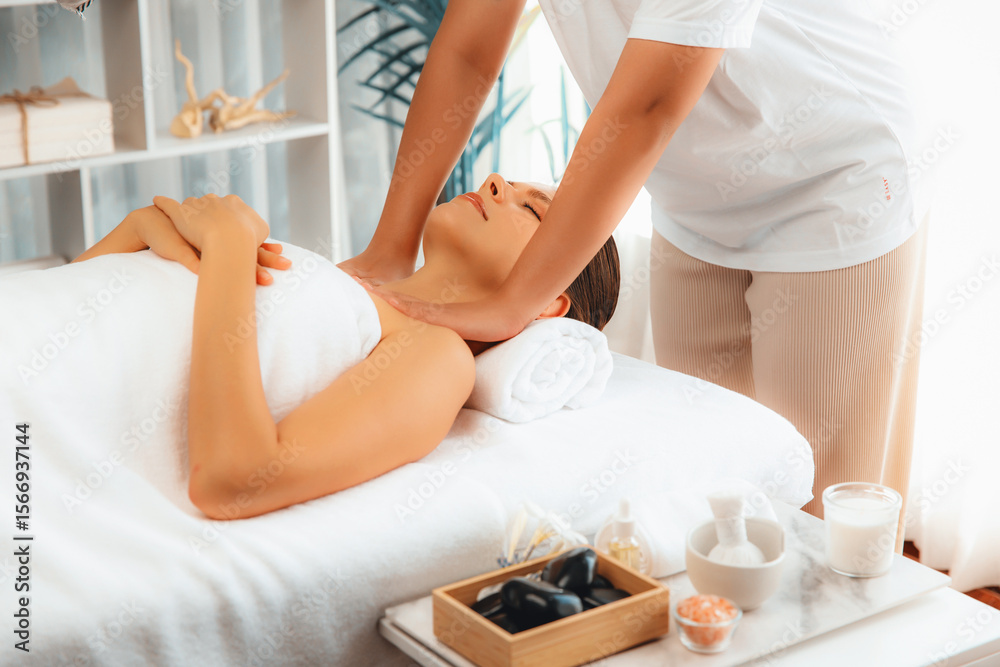 Obraz premium Caucasian woman customer enjoying relaxing anti-stress spa massage and pampering with beauty skin recreation leisure in day light ambient salon spa at luxury resort or hotel. Quiescent