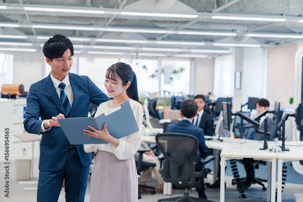 Fototapeta premium オフィスで先輩に相談をする若い女性