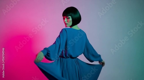 Woman in Blue Dress with Bob Haircut Posing Under Neon Lighting
