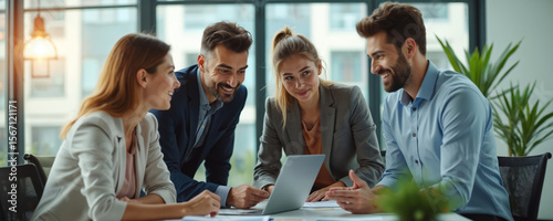 Diverse team of business professionals collaborating, discussing ideas in modern office space. Group works with laptop. Colleagues brainstorming strategies, achieving goals. Teamwork, communication,