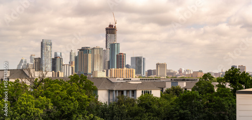 Austin skyline with trees, buildings, and construction crane.