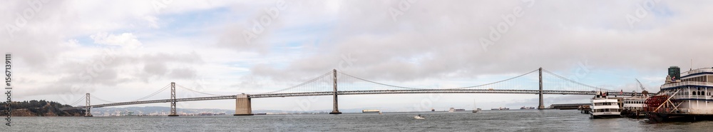 Naklejka premium Panoramic view of the Bay Bridge in San Francisco on a cloudy day.