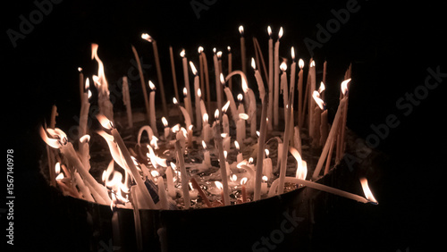 Illuminated candles glow in the darkness, creating a warm and spiritual atmosphere.
