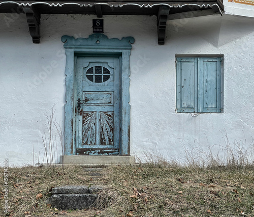 Hellblaue alte Haustür und Fenster mit Fensterladen an einem Haus am Hechtsee, Tirol, Österreich