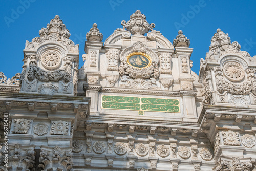 Dolmabahce Palace ornate gate under blue sky. Elaborate Ottoman palace or saray entrance architecture in Istanbul  Turkey. View from internal court. Decorations of buildings  gate  doorways and arches