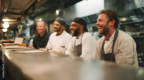 Fototapeta Naklejka Na Ścianę i Meble -  Happy restaurant chefs team laughing together in commercial kitchen professional catering staff scene