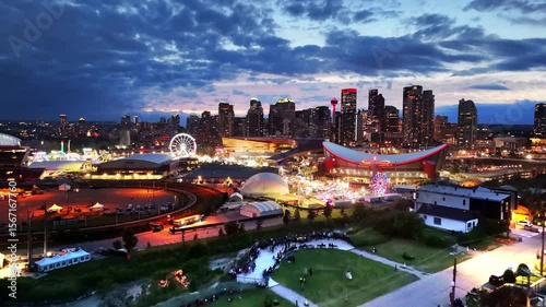 The City of Calgary grounds glow under a dramatic twilight sky, with the city skyline and illuminated attractions captivating the view.