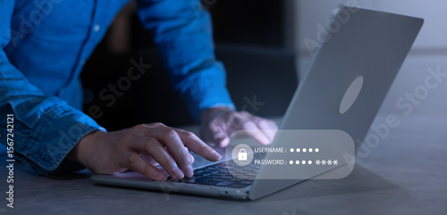 close up developer man hand type keyboard input username and password for register system software on laptop in dark operation office room for cyber security technology concept