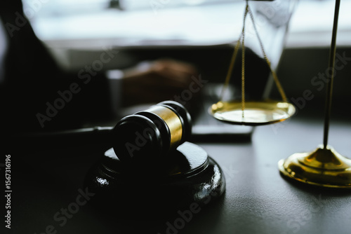 Bild auf Leinwand A gavel sits on a desk beside a laptop as a lawyer works, symbolizing the intersection of modern technology and traditional justice in today’s legal profession