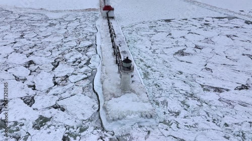 Lighthouse frozen Lake Michigan drone view