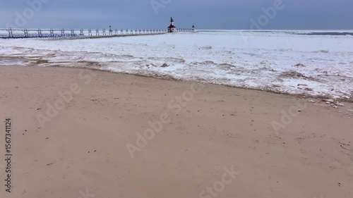 Lighthouse frozen Lake Michigan drone view