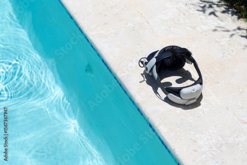XR virtual reality headset rest outside near swimming pool.