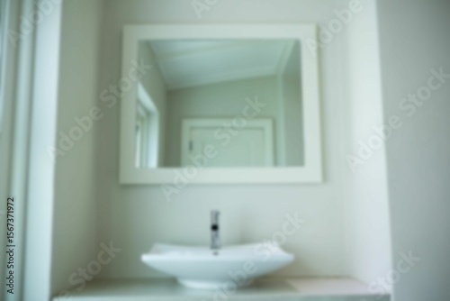 Wash bowl by mirror hanging on wall in bathroom