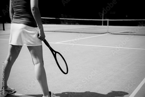 Low section of woman standing with racket